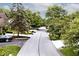 A street view showcasing the road and driveways lined with lush trees and green yards at 5240 Windridge Dr, Indianapolis, IN 46226