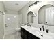 Modern bathroom with double sink vanity, arch mirrors, black fixtures, and a shower-tub combination at 5759 Columbia S Cir, Greenwood, IN 46142