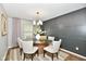 Elegant dining area with glass table, white chairs, modern chandelier, and stylish paneled wall at 5759 Columbia S Cir, Greenwood, IN 46142