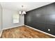 Stylish dining room featuring a black accent wall, hardwood floors, and a modern chandelier at 5759 Columbia S Cir, Greenwood, IN 46142