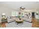 Spacious living room boasts hardwood floors, a neutral sofa, and views of the adjacent bright kitchen at 5759 Columbia S Cir, Greenwood, IN 46142