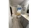 Clean bathroom with a shower/tub combo, gray vanity, and neutral tile flooring at 6027 Moonseed Cir, Indianapolis, IN 46203