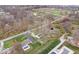 Aerial view of a home with a pool, driveway, and a detached garage at 6120 E Southport Rd, Indianapolis, IN 46237