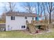 View of the back of the home featuring a raised deck and stairs to the yard at 6120 E Southport Rd, Indianapolis, IN 46237