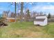 The backyard has grass, a wooden fence, a wooden shed and a metal shed at 6120 E Southport Rd, Indianapolis, IN 46237