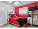 Bedroom with a bed and red accent wall, with a ceiling fan, plus additional storage at 6120 E Southport Rd, Indianapolis, IN 46237