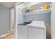 Laundry room with a side-by-side washer and dryer, and shelving for storage at 6120 E Southport Rd, Indianapolis, IN 46237