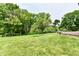 The backyard features a manicured lawn, mature trees, and a wooden deck at 6851 Azalea Dr, Indianapolis, IN 46214