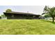 The backyard features a gentle slope, a well-maintained lawn, and the house's rear facade at 6851 Azalea Dr, Indianapolis, IN 46214