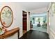 Foyer view featuring decorative mirror, wood flooring, and a glimpse into the spacious living room at 6851 Azalea Dr, Indianapolis, IN 46214