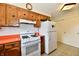 A kitchen featuring wood cabinets, an orange countertop, and white appliances at 6851 Azalea Dr, Indianapolis, IN 46214