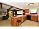 Eat-in kitchen featuring wood cabinets and an orange countertop with seating and modern appliances at 6851 Azalea Dr, Indianapolis, IN 46214