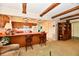 Open living room/kitchen layout featuring wood cabinets, orange countertop, and beamed ceilings at 6851 Azalea Dr, Indianapolis, IN 46214