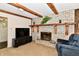 Cozy living room features a brick fireplace with wooden mantel and beams, and comfortable seating at 6851 Azalea Dr, Indianapolis, IN 46214