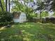 Backyard featuring mature trees, a small shed, and a wooden fence at 7831 E 46Th St, Indianapolis, IN 46226