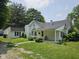 A quaint home with a well-maintained lawn and a detached garage, painted in a clean white at 7831 E 46Th St, Indianapolis, IN 46226