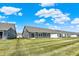 Rear view of home shows a green backyard, patio, well-maintained lawn and neighboring houses under a blue sky at 843 Garrow Dr, Westfield, IN 46074