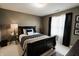 Cozy bedroom with dark wood furniture, neutral walls, and a window with sheer curtains at 8785 W 100 N, Anderson, IN 46011
