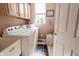 Functional laundry room with washer, dryer, and upper cabinets for storage at 8785 W 100 N, Anderson, IN 46011