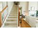 Carpeted staircase with wood banister leading to a bright living area at 8785 W 100 N, Anderson, IN 46011