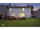 A backyard featuring a wooden deck, lush lawn, and the rear view of the home with windows and a sliding glass door at 8877 N White Tail Trl, McCordsville, IN 46055