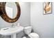 Powder room featuring a pedestal sink, decorative mirror, and modern fixtures at 8877 N White Tail Trl, McCordsville, IN 46055
