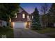Charming two-story brick home with a well-maintained lawn and mature trees at dusk at 8877 N White Tail Trl, McCordsville, IN 46055