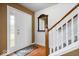 Inviting foyer with wood floors, a decorative mirror, and a staircase at 8877 N White Tail Trl, McCordsville, IN 46055
