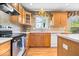 Well-lit kitchen with stainless steel appliances, wood cabinetry, and tiled backsplash at 8877 N White Tail Trl, McCordsville, IN 46055
