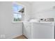 Bright laundry room with modern washer and dryer, shelving, and natural light at 8877 N White Tail Trl, McCordsville, IN 46055