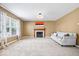Spacious living room with a fireplace, large window, and neutral carpeting at 8877 N White Tail Trl, McCordsville, IN 46055