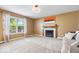 Open living room with a fireplace, large window, and neutral carpeting at 8877 N White Tail Trl, McCordsville, IN 46055