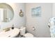 Charming powder room with round mirror, small sink, nautical decor, and soft grey paint at 9053 Fitzgerald Dr, Indianapolis, IN 46239