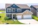 Beautiful two-story home showcasing a blue facade, brick accents, a well-manicured lawn, and a two-car garage at 9053 Fitzgerald Dr, Indianapolis, IN 46239