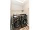 This laundry room has modern front-load washer and dryer, white wire shelving and a skylight at 9053 Fitzgerald Dr, Indianapolis, IN 46239