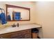 Cozy bathroom with wood vanity, solid surface countertop, framed mirror and warm lighting at 919 Dreamy St, Greenwood, IN 46142