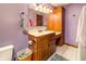 Cozy bathroom with wood vanity, laminate countertop, vanity lighting, and lilac walls at 919 Dreamy St, Greenwood, IN 46142