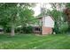 Rear exterior showcasing brick and siding details, a lush lawn, and mature trees for privacy at 919 Dreamy St, Greenwood, IN 46142