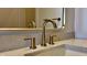 Close-up of a stylish bathroom sink featuring elegant bronze fixtures and a refined countertop, reflecting modern design at 925 Veterans Way # 101, Carmel, IN 46032