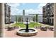 Charming courtyard showcasing lush green space, a decorative fountain, and inviting seating areas at 925 Veterans Way # 101, Carmel, IN 46032