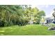 Lush backyard features a fire pit, play set, covered patio, and mature trees at 9710 Iroquois Ct, Indianapolis, IN 46256
