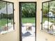 The view from this home features an open door looking out over a patio, yard and play set at 9710 Iroquois Ct, Indianapolis, IN 46256