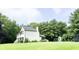 Exterior view of home with spacious yard, play set, and mature trees at 9710 Iroquois Ct, Indianapolis, IN 46256