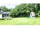 Landscaped backyard featuring a screened porch, a play set, and mature trees at 9710 Iroquois Ct, Indianapolis, IN 46256