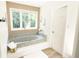 Bathroom with a soaking tub, neutral walls, and a bright window showcasing outdoor views at 9710 Iroquois Ct, Indianapolis, IN 46256