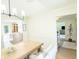 Dining area with light wood floors and table, with a view of kitchen and entryway at 9710 Iroquois Ct, Indianapolis, IN 46256