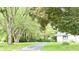 A tree-lined driveway leads to a house with a basketball hoop in the yard at 9710 Iroquois Ct, Indianapolis, IN 46256
