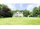 Exterior view of home with spacious yard, play set, and mature trees at 9710 Iroquois Ct, Indianapolis, IN 46256