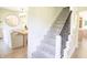Carpeted staircase featuring a dark railing and natural light, adjacent to a dining room at 9710 Iroquois Ct, Indianapolis, IN 46256