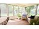 Bright sunroom with views of the backyard, wood floors, and comfortable seating at 9710 Iroquois Ct, Indianapolis, IN 46256